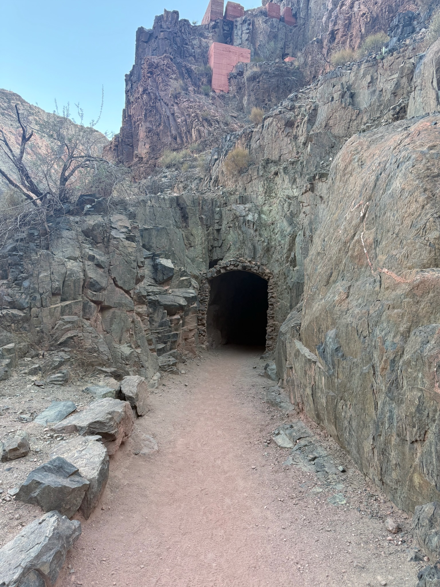 The trail enters a stone tunnel carved into the canyon wall