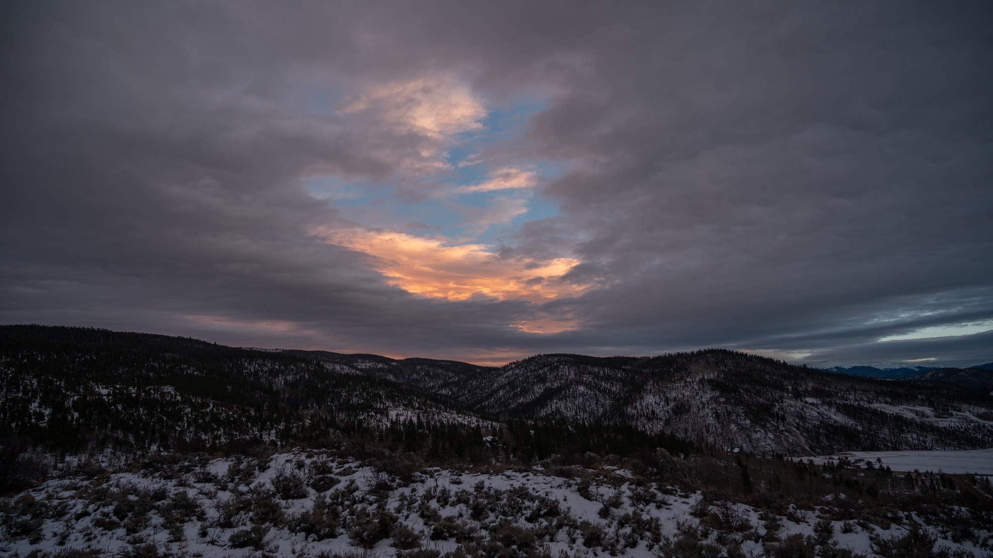Dawn light breaking over snow-covered ridgelines